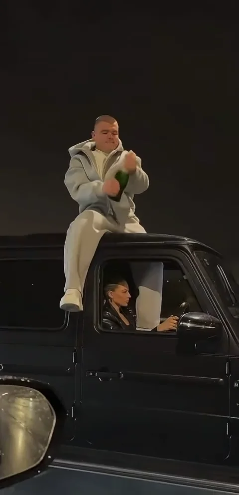 Grey tracksuit · car roof · 9 s · with sound